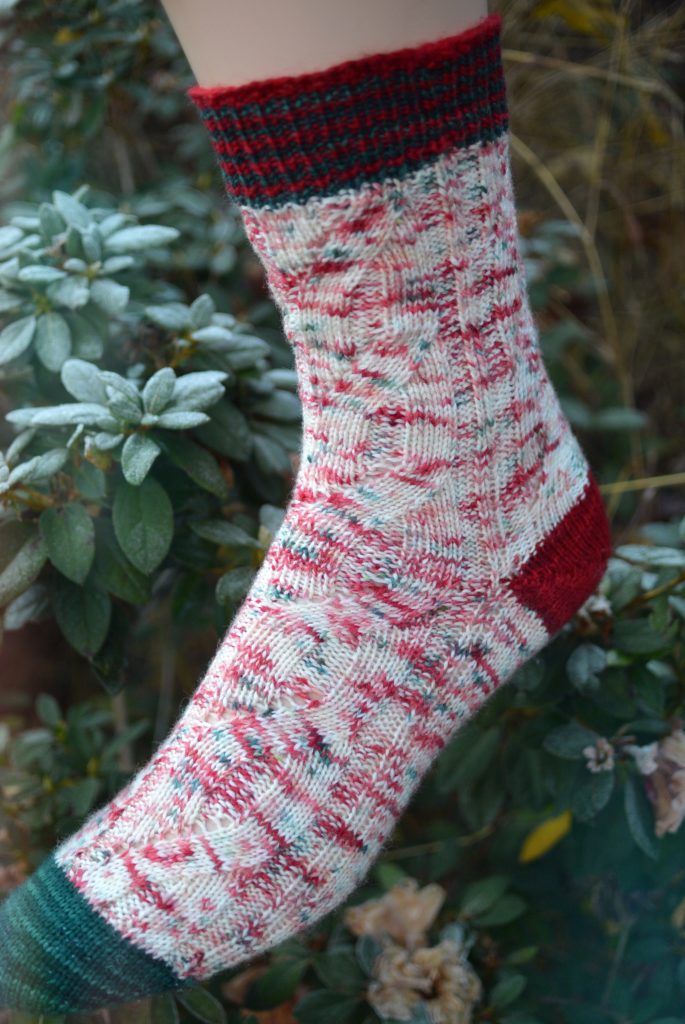 Faux cable sock in holiday colors of red, green, and white.